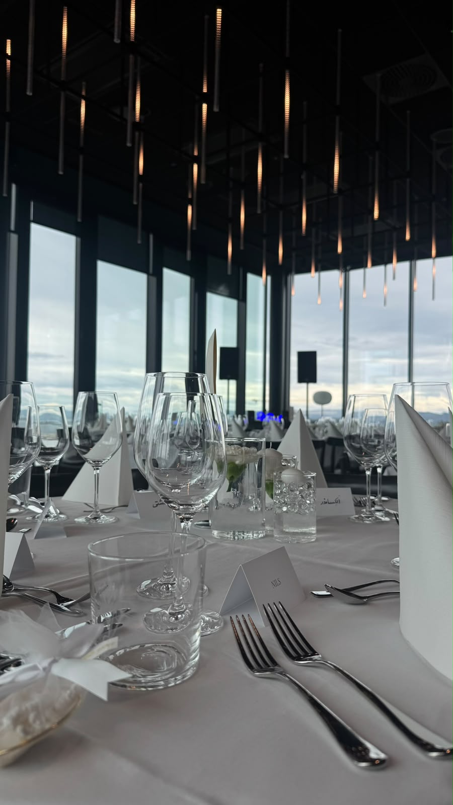 Glassware and white napkins beneath warm pendant lights