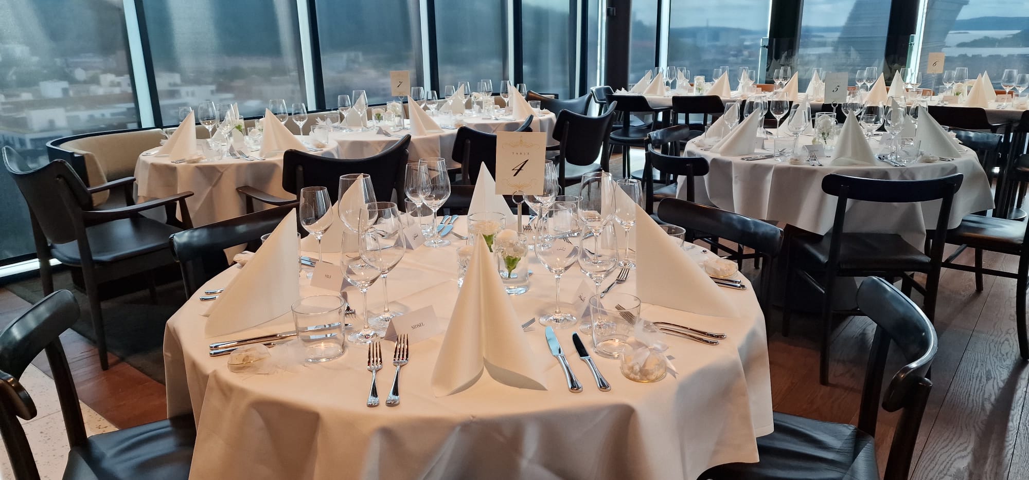 Round tables with white linens and black chairs